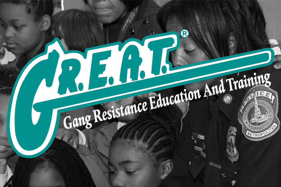Gang Resistance Education and Training Logo overtop police officer helping kids