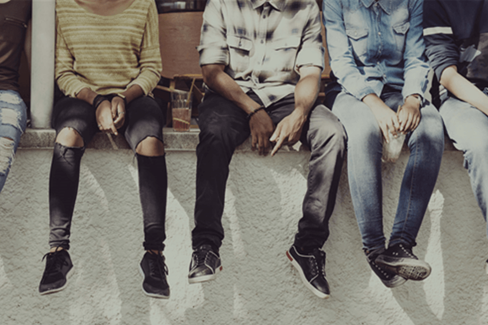 group of teens sitting on cement ledge