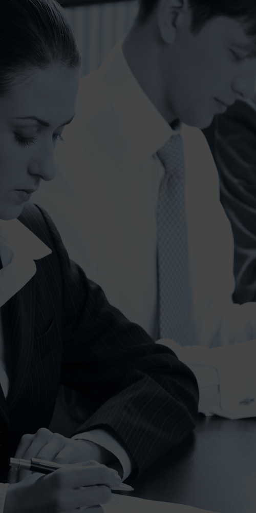 two people in business attire sitting at a desk