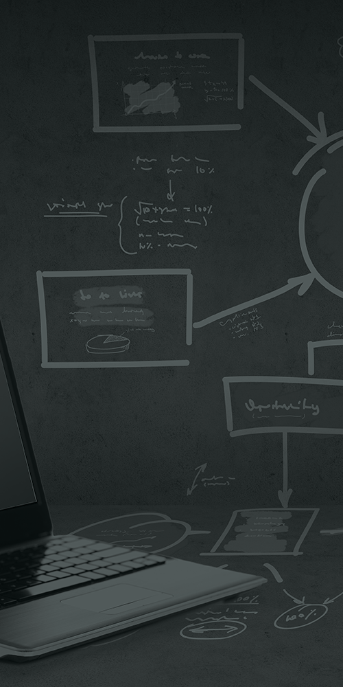 a laptop in front of a chalkboard with diagrams on it