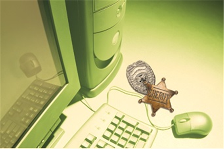 sheriff badges on a desk next to computer equipment