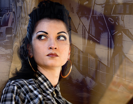 a woman against a graffiti background looking up and away from the camera