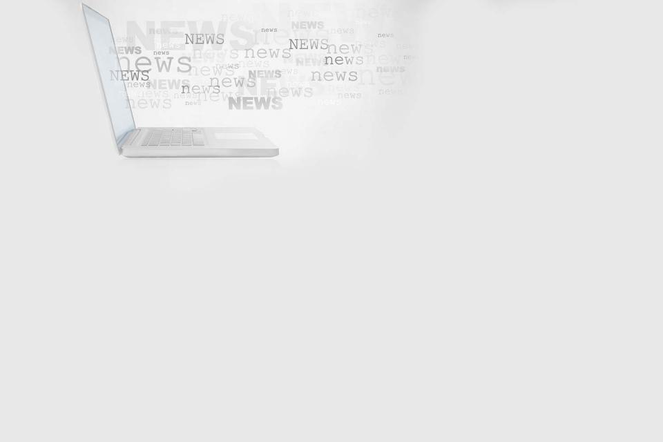 a laptop with the word "news" printed multiple times in a cloud around it