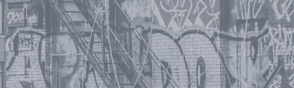 an outdoor staircase in front of a wall covered in graffiti