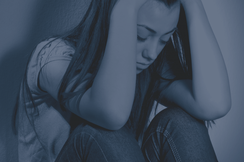 a girl sitting down and looking at the ground
