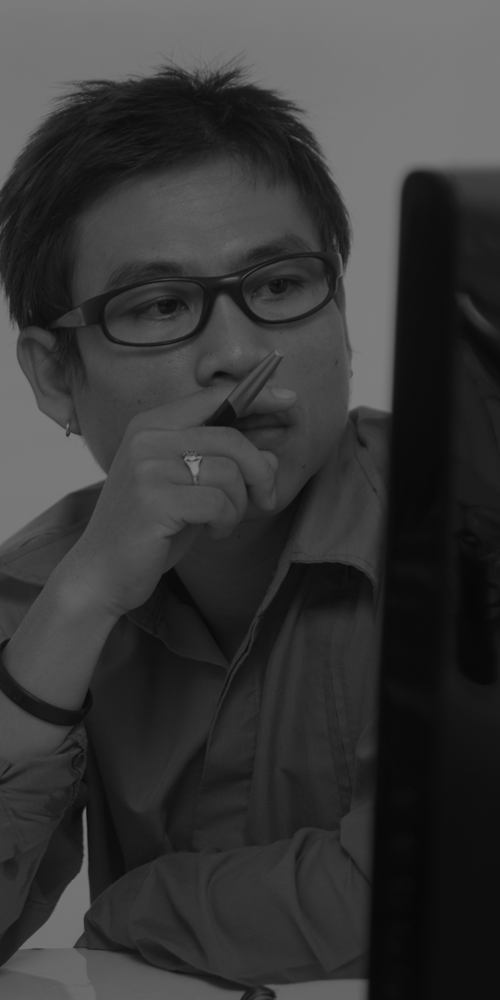 a man holding a pen and looking at a computer screen