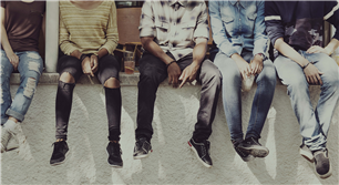 five youth sitting next to each other on a ledge