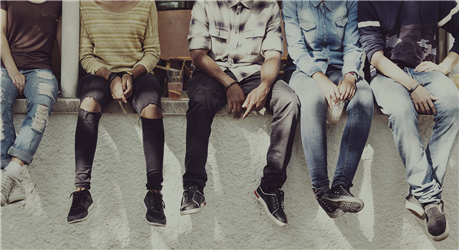 five youth sitting next to each other on a ledge