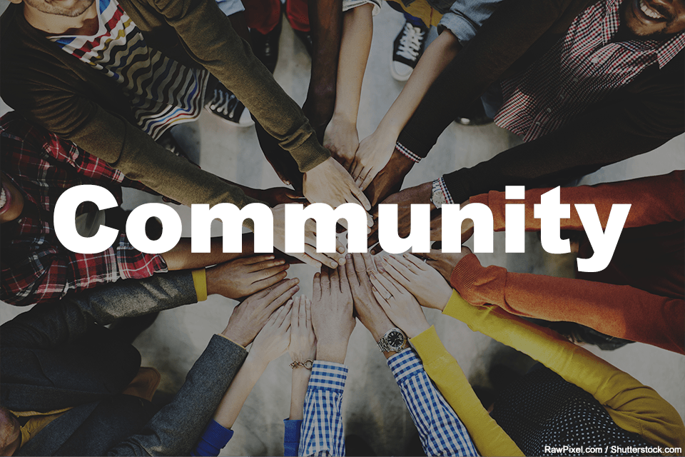 A large group of people putting their hands together in a circle