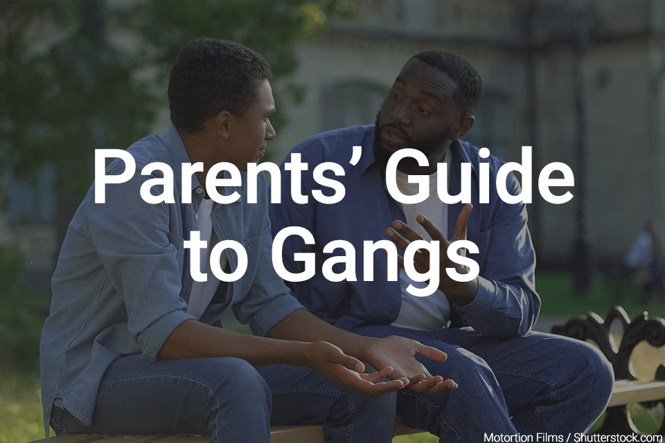 Man talking to his teenage son on park bench