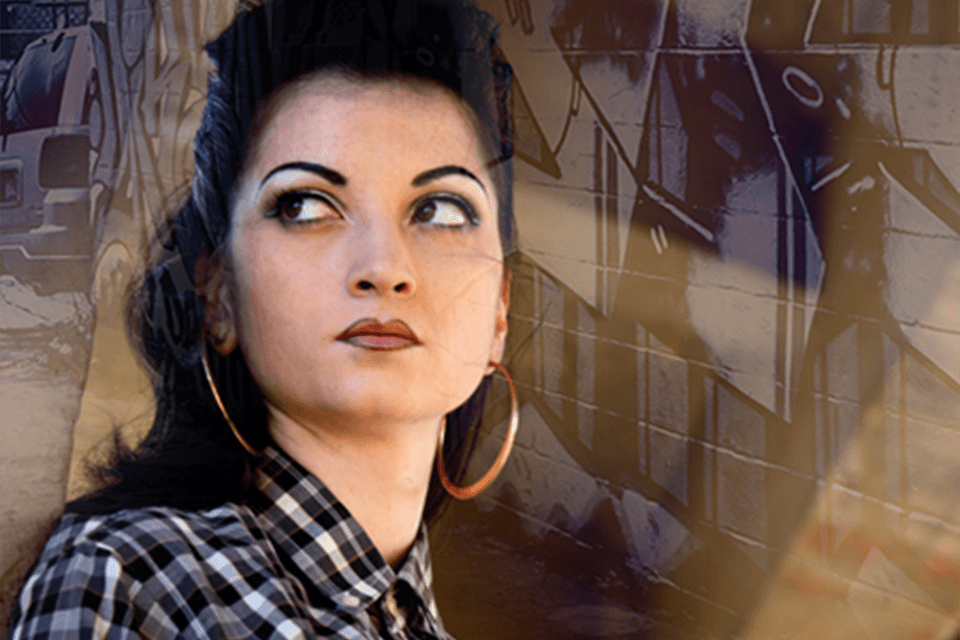 Image of a teenage girl with large hoop earrings and graffiti in the background