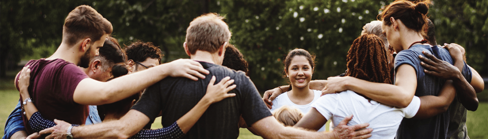 group of diverse people standing arm in arm in a circle